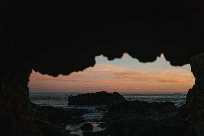 视图是从洞穴在日落的海洋
